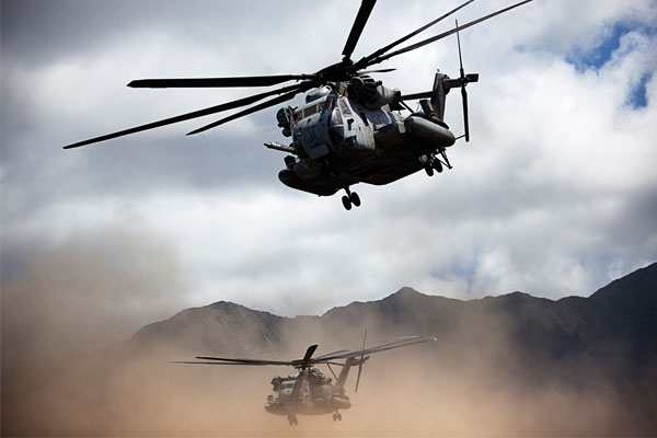 Two U.S. Marine Corps CH-53E Super Stallion helicopters assigned to Marine Heavy Helicopter Squadron (HMH) 463 take off after delivering Marines and Canadian soldiers as part of a noncombatant evacuation operation during exercise Rim of the Pacific (RIMPAC) 2012 at Marine Corps Training Area Bellows, Marine Corps Base Hawaii, Kaneohe Bay, Hawaii, July 26, 2012. RIMPAC is a U.S. Pacific Command-hosted biennial multinational maritime exercise designed to foster and sustain international cooperation and security on the world