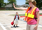 A crossing guard helps a child.