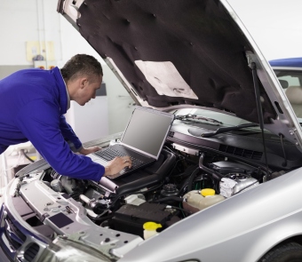 Image of mechanic looking under the hood of a car