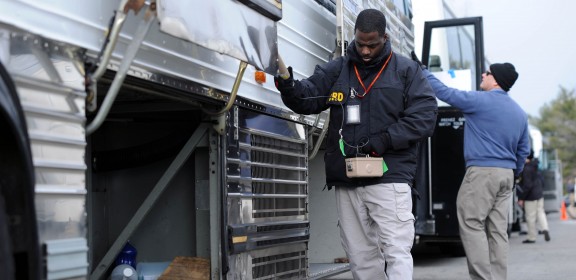 CBRNE specialist Terrance Allen (front) conducts a technical sweep of a bus in the Pentagon north parking lot, while a security official from a partnering agency (back) conducts a visual sweep.