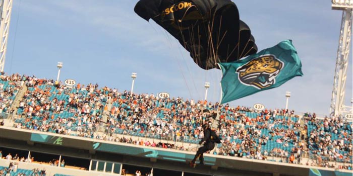 Lt. Col. Ken Ates brings in the Jaguars Team Flag during half time