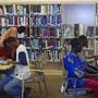 Library members read books, magazines, and other reference materials (State Dept) 

