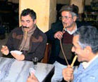 Men seated around table smoking water pipes