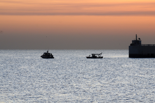 Coast Guard and Navy boats patrol the entrance to the Kuwait Naval Base. U.S. Coast Guard photo by Chief Warrant Officer Scott Epperson.