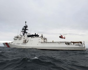 An MH-65 Dolphin helicopter flies by the Coast Guard Cutter Bertholf in the Arctic Ocean. The air crew from Air Station Los Angeles was attached to the ship as part of Operation Arctic Shield. U.S. Coast Guard photo by Petty Officer 1st Class Timothy Tamargo.