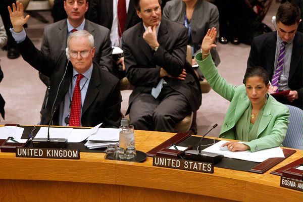 Permanent representatives from the United Kingdom, Mark Lyall Grant, left, and the United States, Susan Rice, right, vote to approve a resolution that will impose a no-fly zone over Libya during a meeting of the United Nations Security Council at UN headquarters