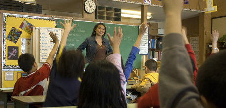 students raising their hands in a classroom