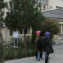 2 people walking in front of a building