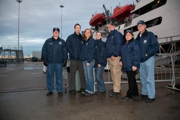 Melinda McDonough, team leader of Community Relations Team 31, with her team in front the training ship TS Kennedy.
