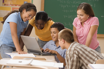 A group of students working on an assignment in class using a laptop; ThinkStock.com