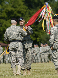 Courtesy photo by Jill Pickett, The News Enterprise; Col. Brig. Gen. Donald MacWillie, Deputy Commander of the 1st Infantry Division, transferred the Brigade colors to Ostlund while Toner looks on during the ceremony