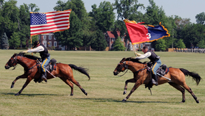 Photo by U.S. Army Staff Sgt.
Michael Lemmons, 3/1 IBCT Public Affairs; Soldiers of the 1st Infantry Division Commanding General's Mounted Color Guard (left) charge Brooks field in traditional fashion