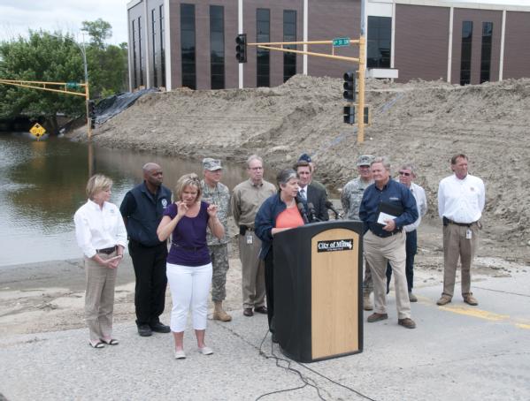 Minot, ND, July 13, 2011 -- Secretary Janet Napolitano and North Dakota Governor Jack Dalyrmple appear at a press conference with local ,state and other federal officials. Napolitano and Dalyrmple did an aerial survey of the areas still under water in Minot and the surrounding towns. Napolitano and FEMA officials promised to continue to provide assistance to residents affected by recent floods.