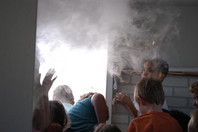 elementary school students listen to instructions from Fire Inspector Dave Land on how to exit a burning building.