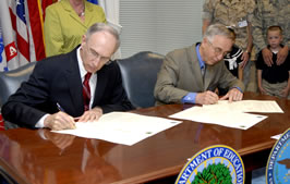 Deputy Secretary of Defense Gordon England and Deputy Secretary of Education Raymond Simon sign the agreement.
