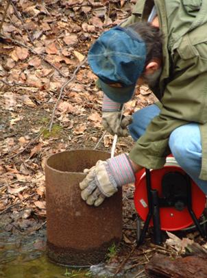 Hydrologist taking water level measurements in a monitoring well completed in an abandoned underground mine in Pennsylvania. 