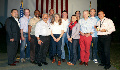 group of men and women poses in front of American flag