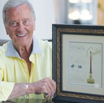 PAT BOONE holds up the framed Christmas card on which he wrote the lyrics to his song.