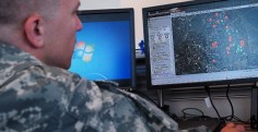 Maj. Nick Miller demonstrates the internal web-based app used by employees of Arlington National Cemetery since March 12. The orange icons on the screen's map indicate where maintenance is being conducted and the green icons indicate where burials will take place that day. (DOD photo by Gary Sheftick, Army News Service)