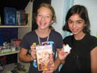 Two girls showing a book from our library.