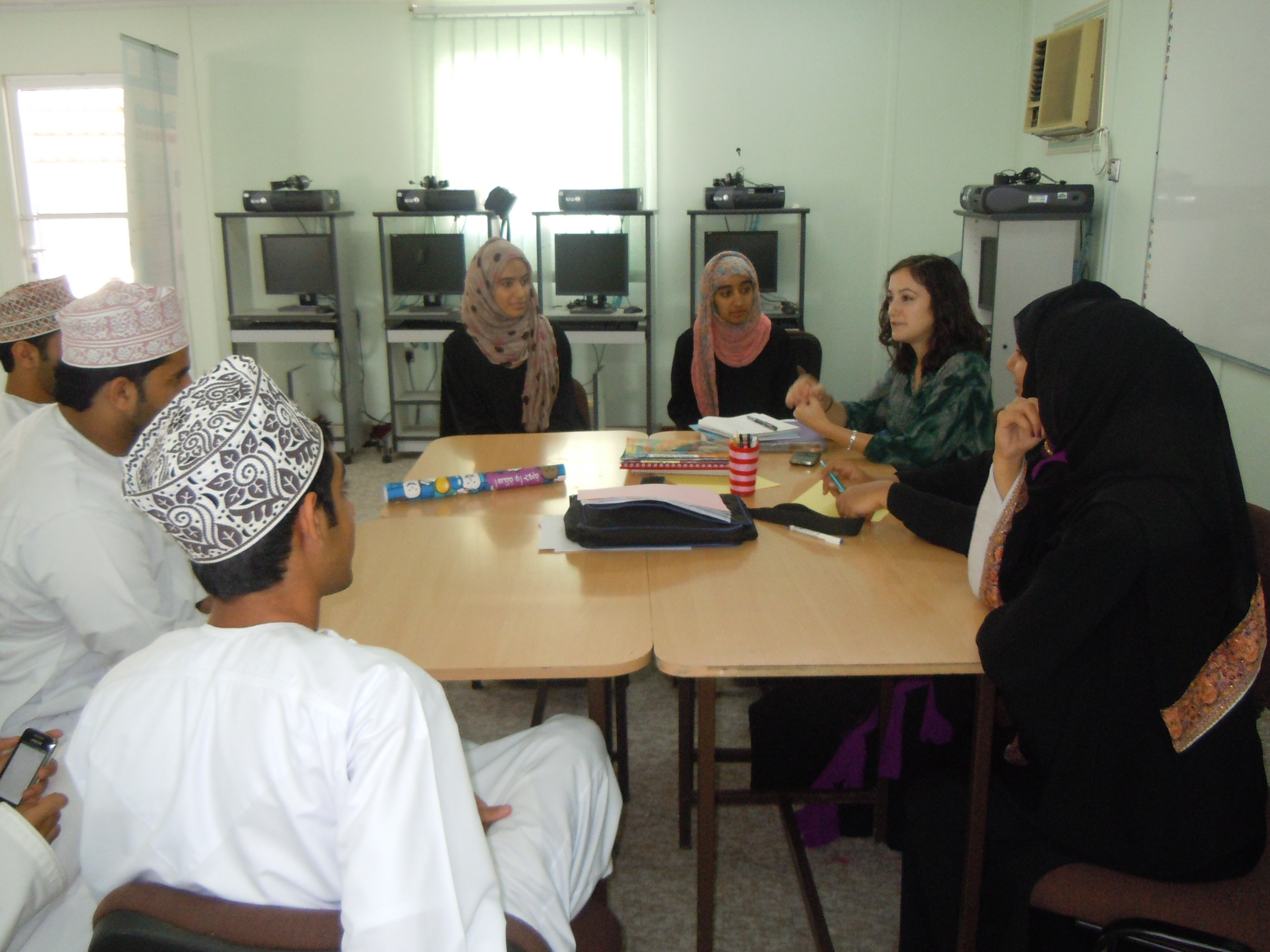 Students with Embassy Staff sitting around a table (US Emb. Muscat)
