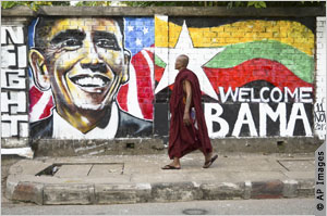 A monk walks by graffiti welcoming President Obama to Rangoon. Obama will be the first U.S. president to visit Burma. Photo: ©AP Images