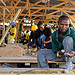 Individuals prepare shelter materials for construction