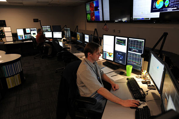 Space Weather Forecasters Monty Spencer (foreground) and Jeff Stankiewicz (background) analyze space weather data in the new SWPC Forecast Center.
