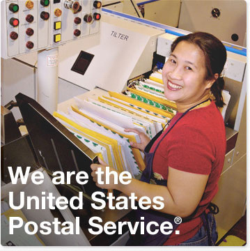 We are the United States Postal Service. A female USPS employee in a red shirt and a Postal apron is smiling while standing at a mail sorting machine. She is sifting through dozes of envelopes stacked on a conveyor.