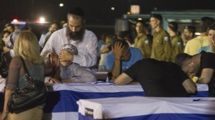 Relatives mourn over the coffins of people killed in a bombing in Bulgaria as the remains arrived back at an airport in Tel Aviv, Israel, July 20, 2012.  