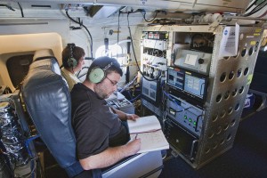 Terry Lathem, a graduate student in Georgia Tech’s School of Earth and Atmospheric Sciences, takes notes aboard a NASA DC-8 aircraft gathering samples of microorganisms in the atmosphere. (Photo: NASA)