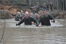 The Basic School’s Artillery Instructor Battery teams push their log through the freezing cold water during the Montfort Point Challenge competition at the Officer Candidates School on Feb. 8. This was the last obstacle the Marines had to go through before one member in their team climbed a rope and officially stopping the time. 