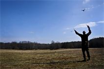 Capt. Joshua Rogerson, The Basic School air officer, signals MV-22 Osprey pilots toward his location during a proof-of-concept training exercise for tactical employment of the Osprey in future operations at Landing Zone Cockatoo on Feb. 6. Combining speed and maneuverability, the Osprey greatly enhances the advantages Marines have over their enemies. 