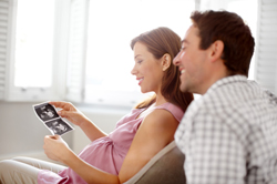 Man and pregnant woman looking at a sonogram