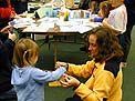 Sandy Baldwin helps a GeoFest participant make a paper nautiloid model