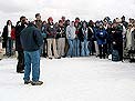 Tony Williams discusses water quality with a group of chilly students on snow-covered Megansett Beach