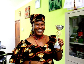 USADF grantee Marvelous Flotea displays an award for her prize winning business