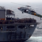 An MH-60S Knighthawk picks up stores from USNS Bridge