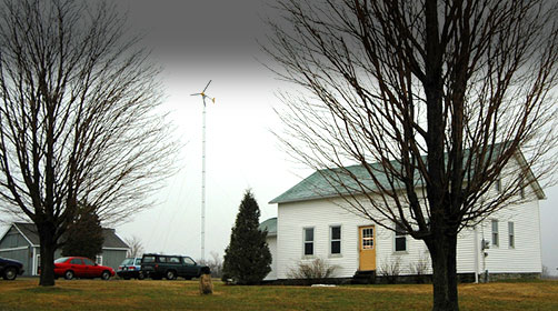 Photo of a small wind turbine beside a farmhouse in New York.