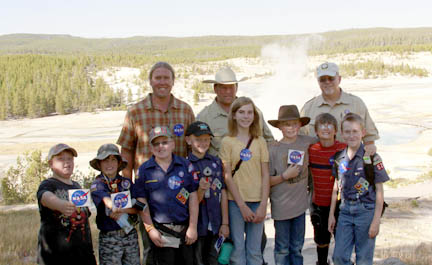 Eric Boyd of MSU and the local Webello Packs stand in front of a geyser basin in Yellowstone National Park.