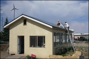 A photo of the wind turbine next to the greenhouse.