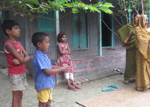 Two women and three children hanging outside