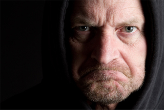 White man wearing hooded sweatshirt frowning