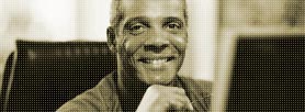 Photo of man smiling while sitting at desk