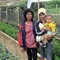 a woman and a mother carrying an infant in a greenhouse environment