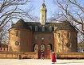 Williamsburg Capitol Building with Woman in Red Cape Standing in Front