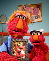 Elmo's dad, Louie, helps Elmo cope with the loss of his Uncle Jack, in picture, during the filming of a Sesame Workshop video aimed at helping military children deal with the loss of a loved one. Elmo wears his uncle's hat in memory and celebration of his uncle's life. The video was filmed in Queens, New York, Oct. 14, 2009. Courtesy photo by Gil Vaknin