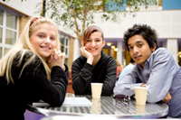 two girls and a guy at a table