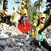 Individuals work to move a pile of rubble