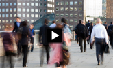 crowd of people walking down a sidewalk